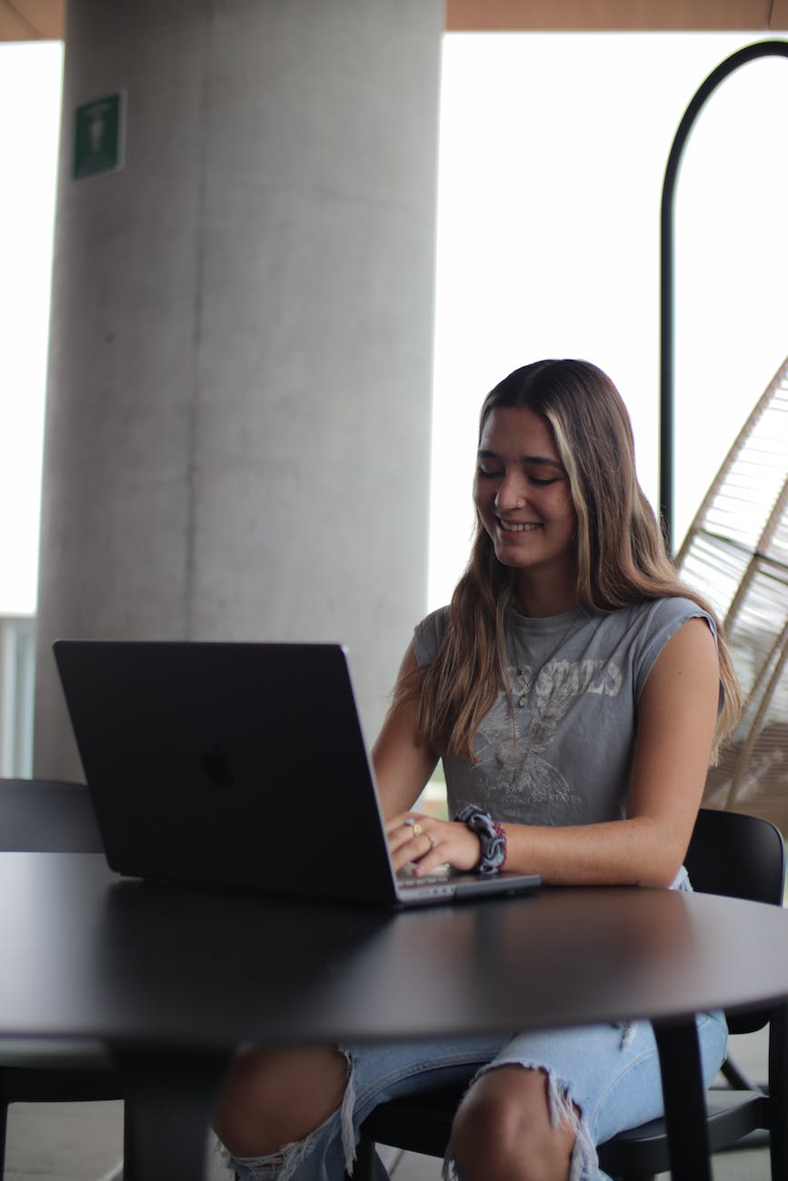 a woman sitting at a table with a laptop