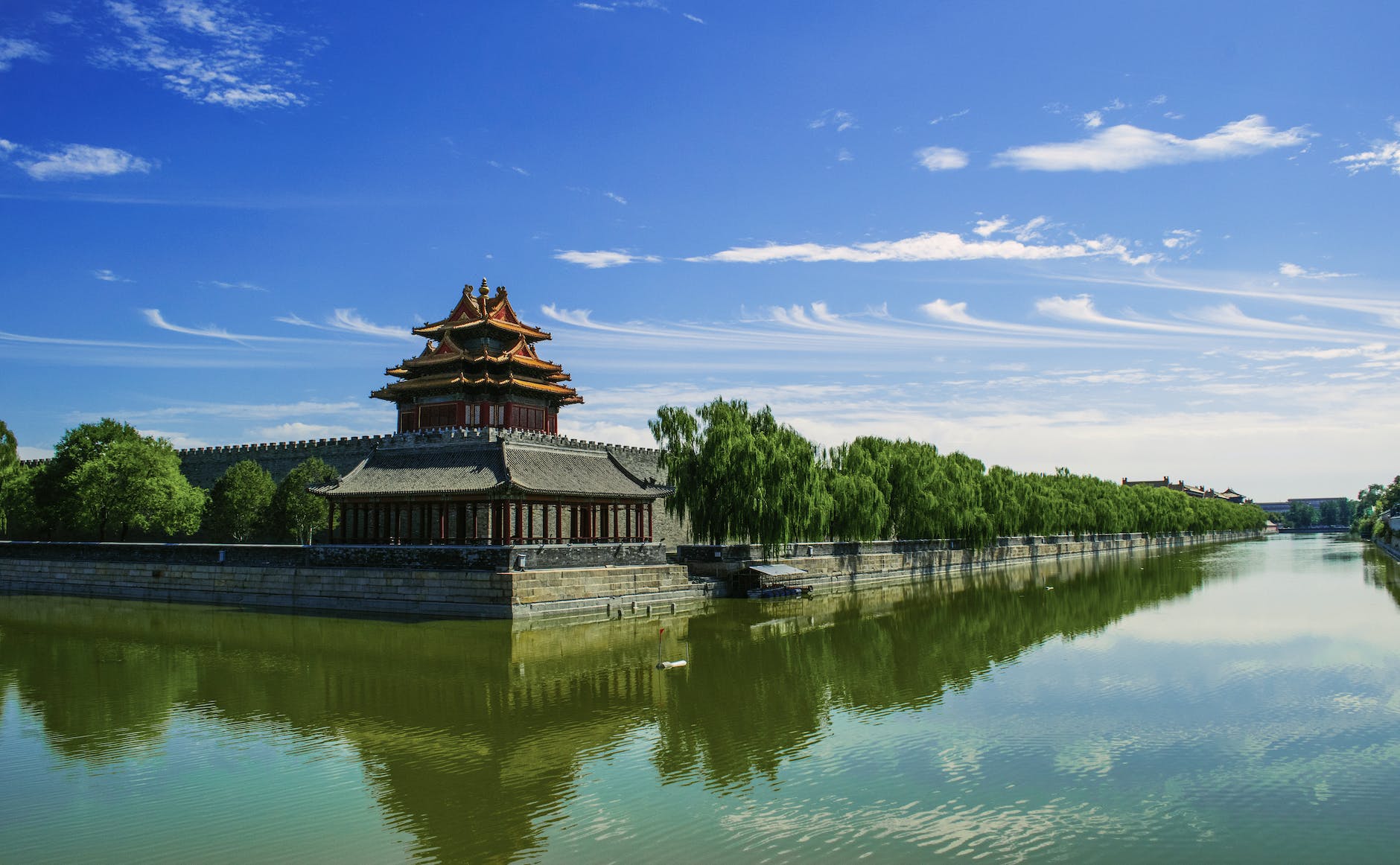 concrete temple near body of water under blue sunny sky