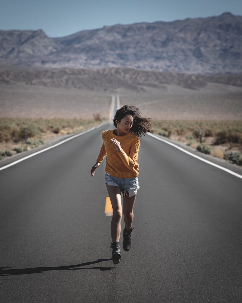 photo of woman running on road